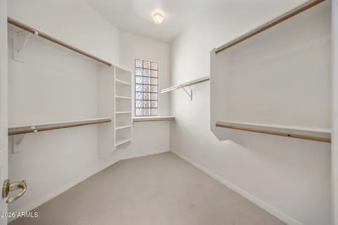 a view of walk in closet with empty racks