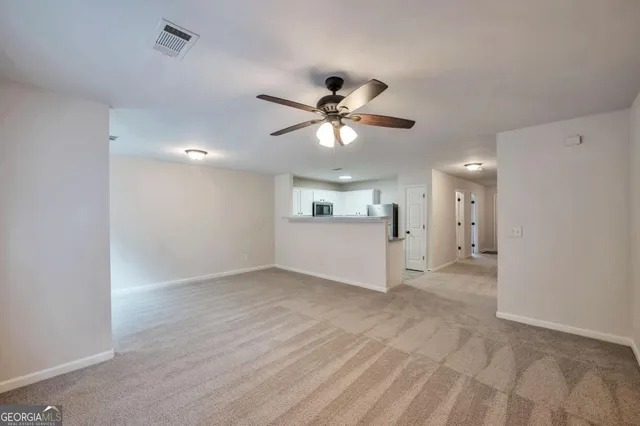 a view of a livingroom with a kitchen island a sink dishwasher and a refrigerator
