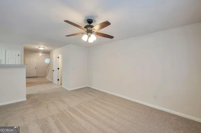 an empty room with a ceiling fan and a fan