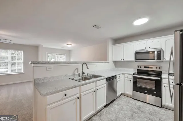 a kitchen with stainless steel appliances granite countertop a sink stove and microwave