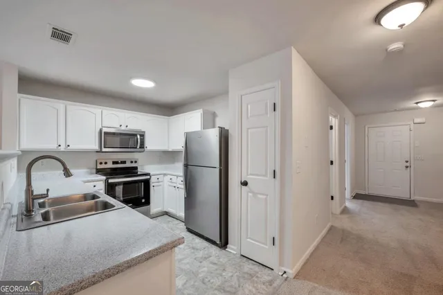 a kitchen with stainless steel appliances granite countertop a refrigerator and a sink