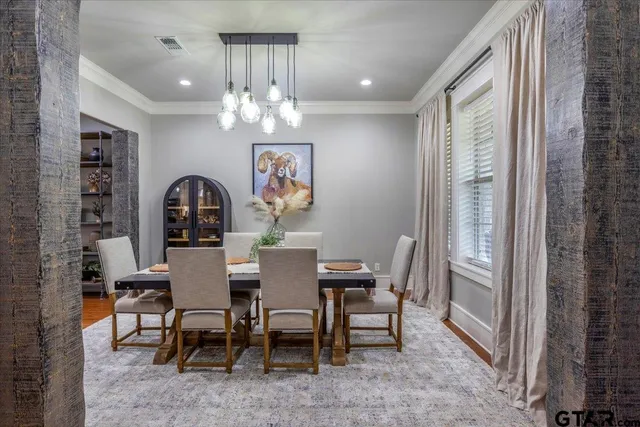 a view of a dining room with furniture a chandelier and window