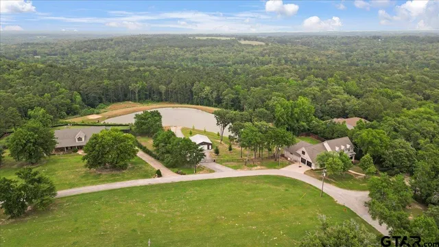 an aerial view of a house with a yard and lake