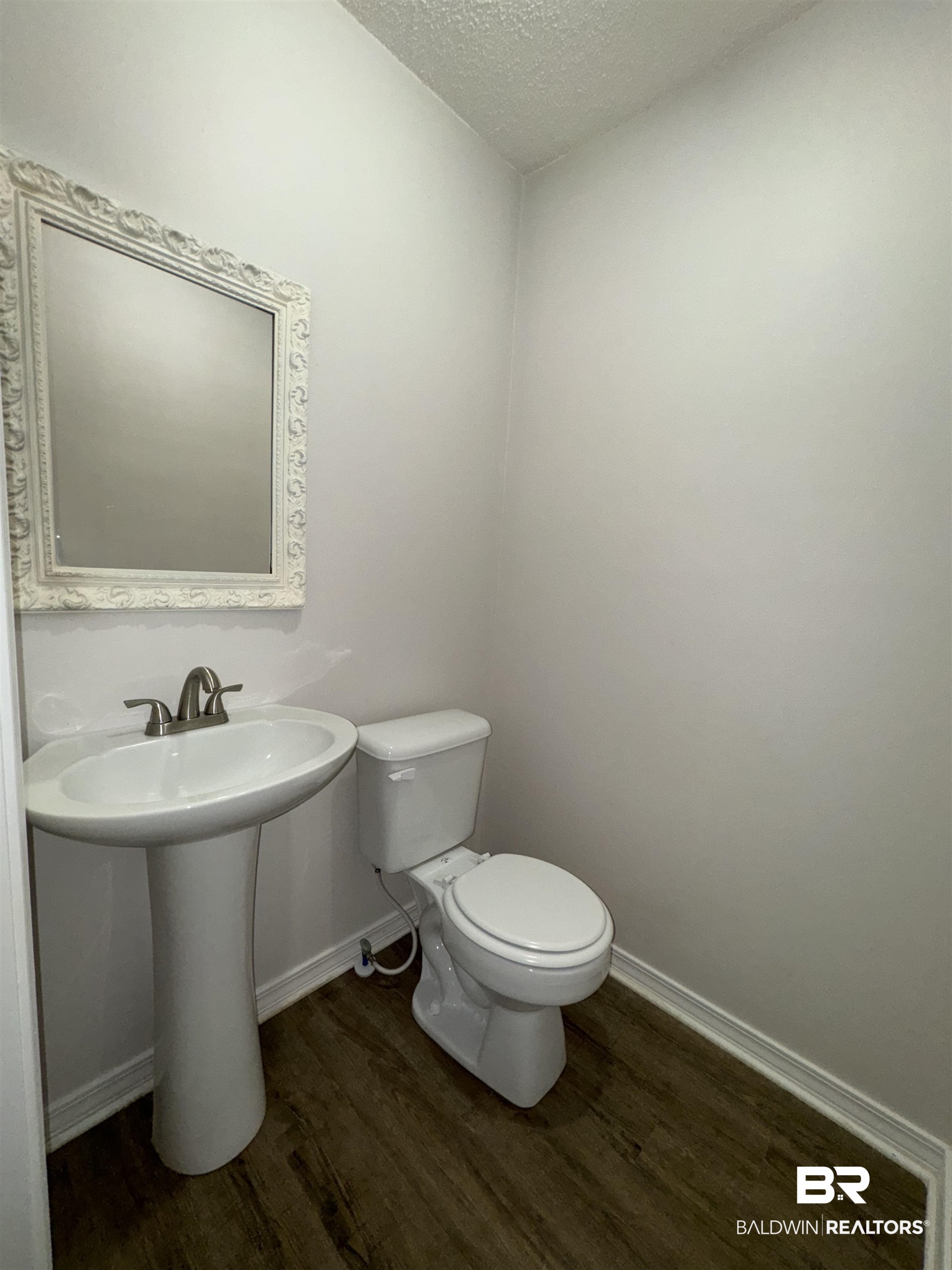 70 Plum Street Uriah, AL 36480 - Photo 10 of 36 Bathroom with wood-type flooring, a textured ceiling, and toilet