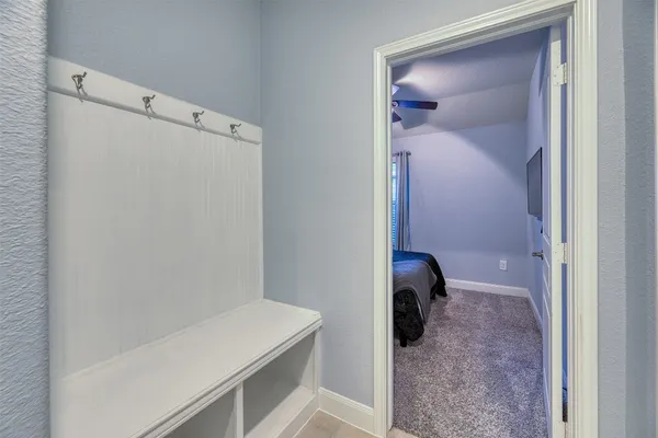 an empty room with windows and chandelier fan