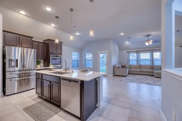a kitchen with kitchen island granite countertop lots of counter top space and stainless steel appliances