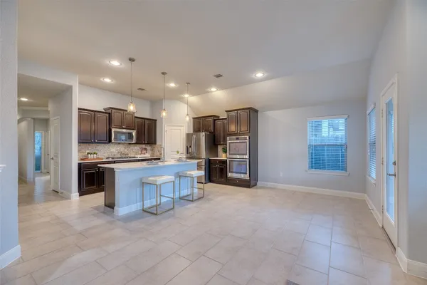 a view of kitchen with stainless steel appliances kitchen island refrigerator stove microwave and oven