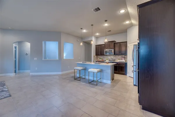 a kitchen with kitchen island granite countertop a sink and a stove top oven