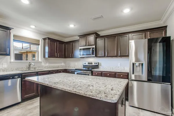 a kitchen with stainless steel appliances granite countertop a sink stove and refrigerator