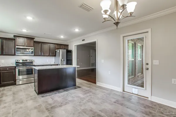 a large kitchen with stainless steel appliances granite countertop a stove and a refrigerator