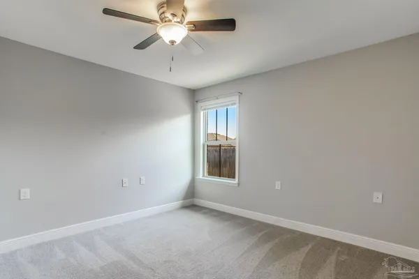 an empty room with closet and a ceiling fan
