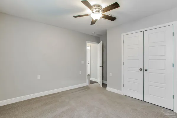 a bathroom with a granite countertop toilet sink and mirror