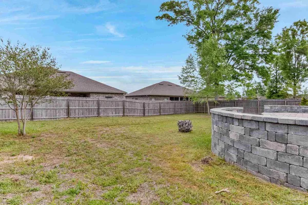 a view of backyard with wooden fence