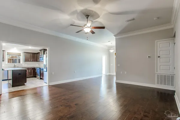 a view of an empty room with wooden floor