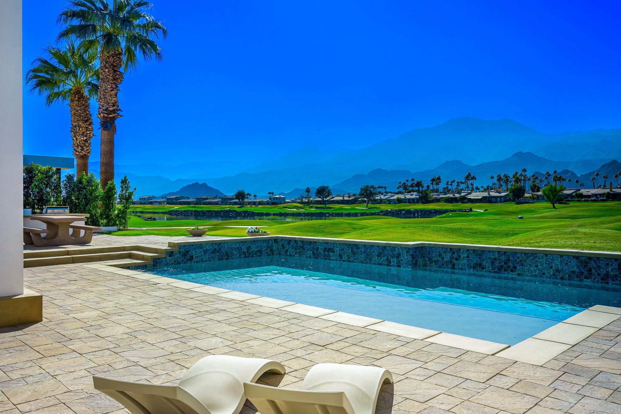 55305 Pebble Beach La Quinta, CA 92253 - Photo 50 of 65 a view of a swimming pool with a yard and palm trees