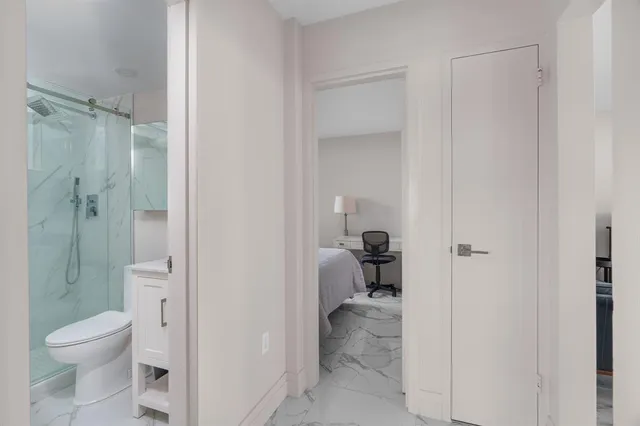 a bathroom with a granite countertop sink a toilet and shower