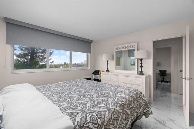 a spacious bedroom with a bed and a large mirror