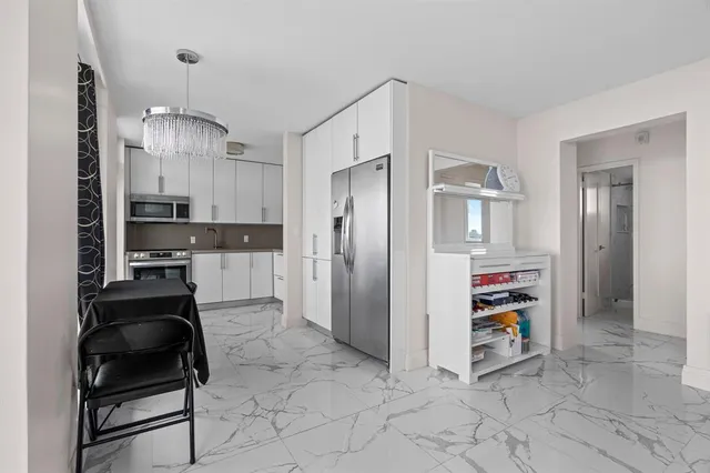 a kitchen with stainless steel appliances granite countertop a refrigerator and a stove top oven