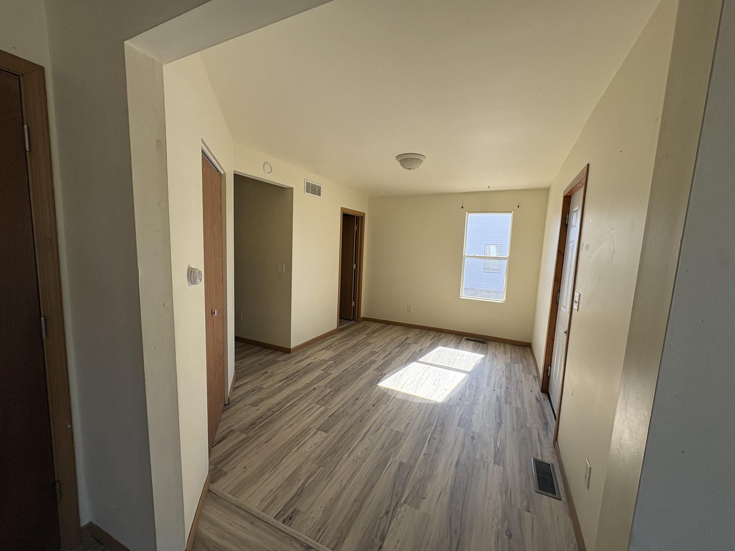 221 North 9th Street Rochelle, IL 61068 - Photo 8 of 17 a view of an empty room with wooden floor and a window