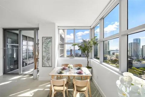 a dining room with furniture and large windows