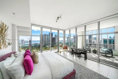 a bedroom with a bed and a large window