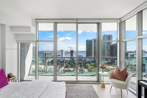 a bedroom with furniture and a large window