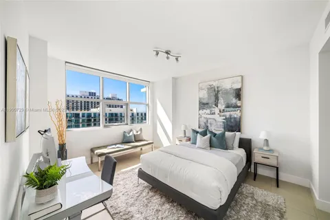 a bedroom with a bed and large window