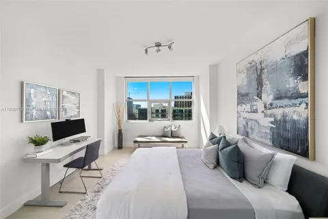 a bedroom with a balcony a bed and large window