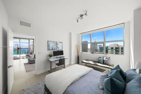 a bedroom with a bed and a flat screen tv