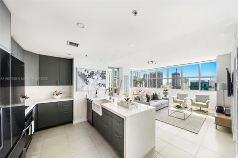 a large room with a lot of white furniture and couches with wooden floor