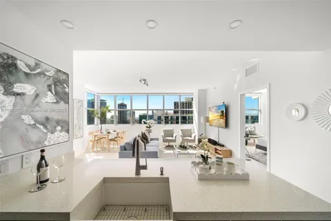 a living room with furniture and view of kitchen