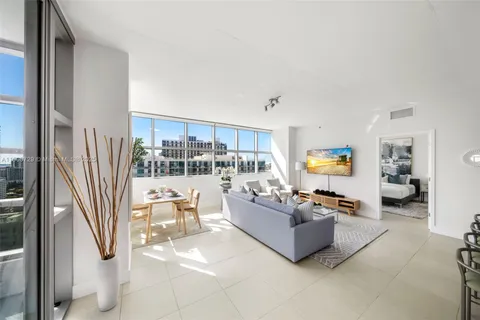 a living room with patio furniture and a flat screen tv