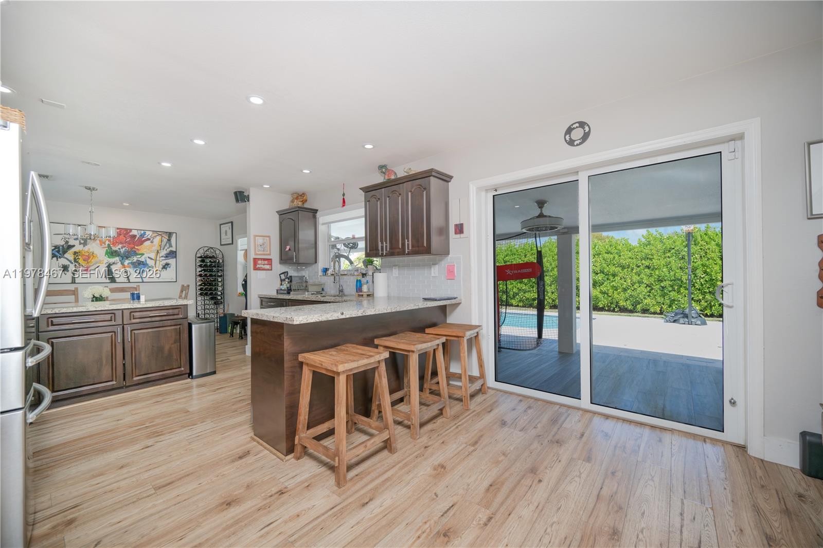 19431 Franjo Road Cutler Bay, FL 33157 - Photo 25 of 32 a open kitchen with stainless steel appliances granite countertop a stove top oven a sink dishwasher and a refrigerator with wooden floor
