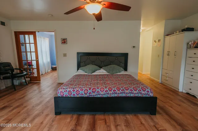 a bedroom with a bed and wooden floor