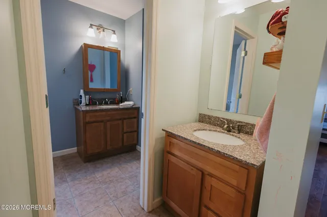 a spacious bathroom with a granite countertop sink and a mirror