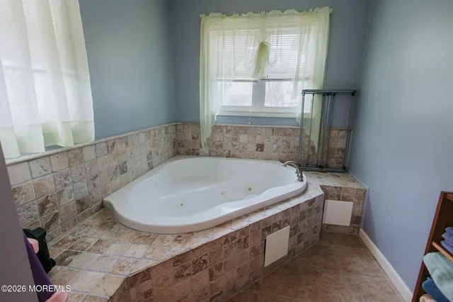 a bath tub sitting in a bathroom next to a window
