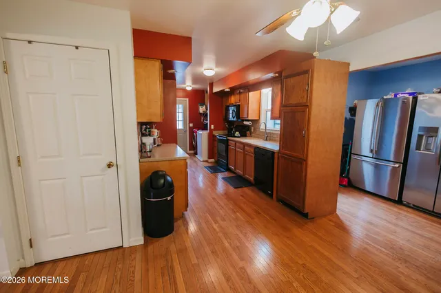 a view of a kitchen with refrigerator and wooden floor
