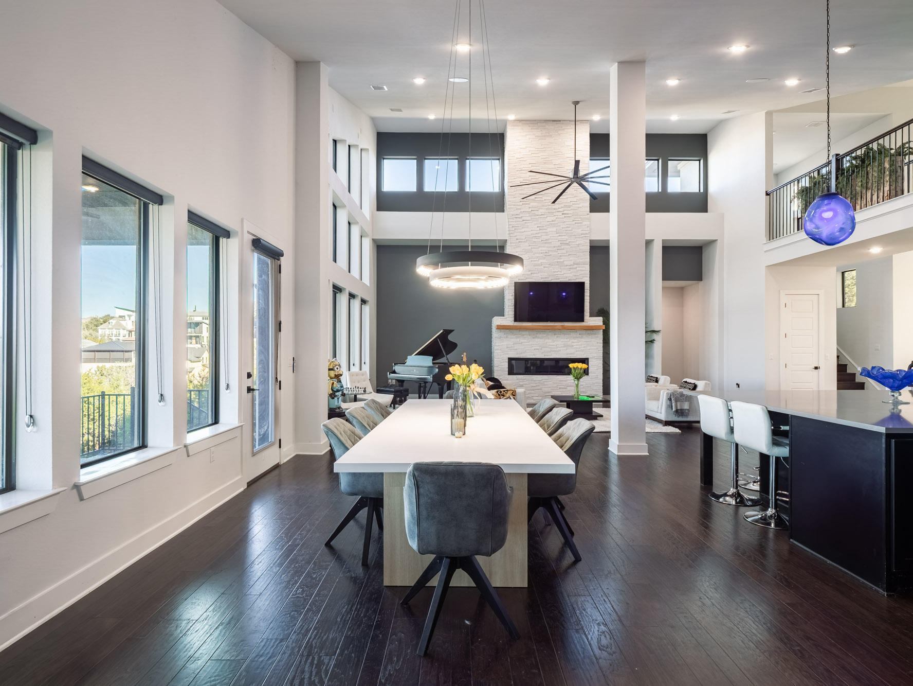 14900 Copper Ridge Lane Austin, TX 78734 - Photo 10 of 39 Dining space with a fireplace, ceiling fan, dark wood-type flooring, and a towering ceiling
