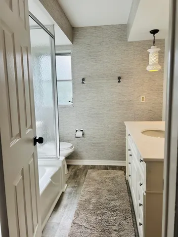 a bathroom with a granite countertop sink toilet and shower