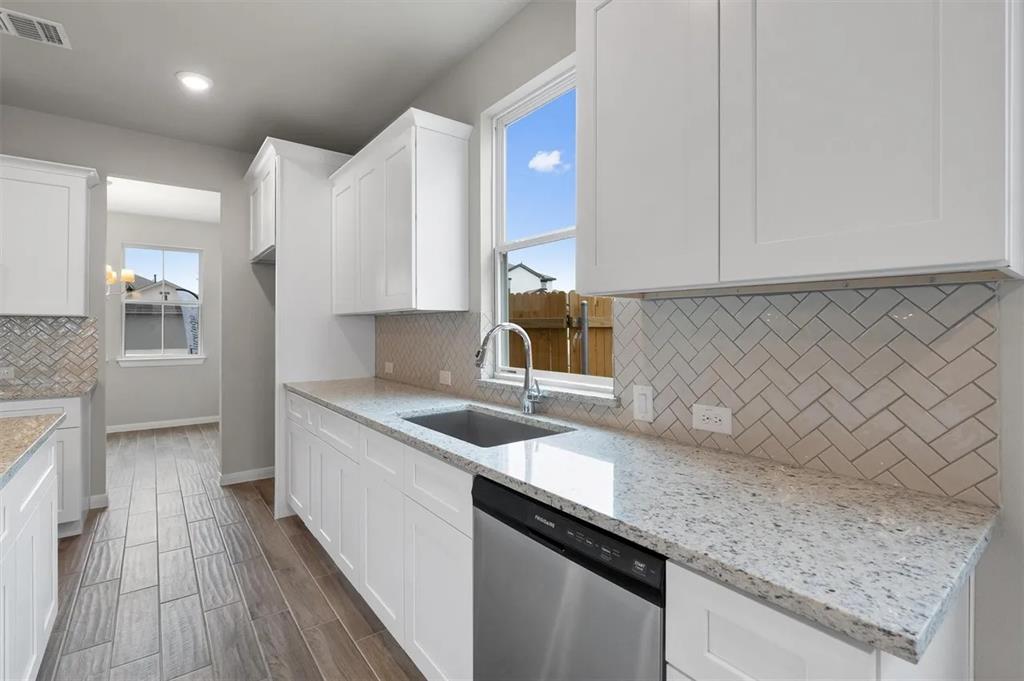332 Stellar Wind Drive Georgetown, TX 78628 - Photo 12 of 29 Bright white cabinetry and a patterned backsplash elevate this functional kitchen space.