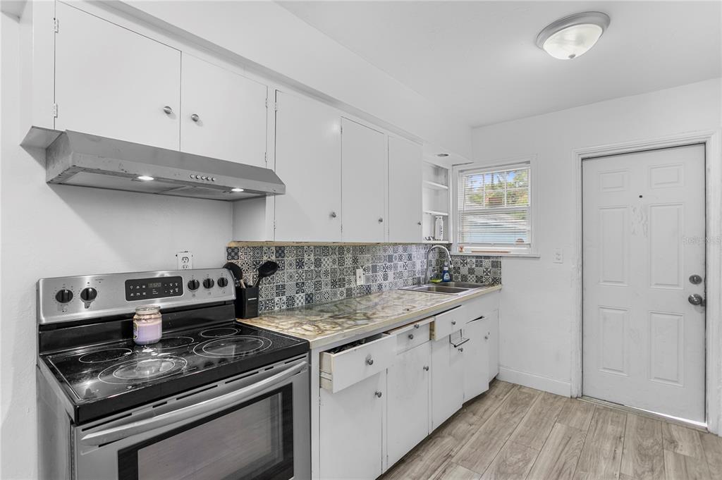 4762 Haines Road North St. Petersburg, FL 33714 - Photo 20 of 29 a kitchen with stainless steel appliances granite countertop a stove and a white cabinets