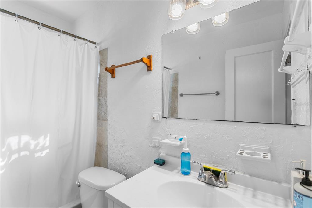 4762 Haines Road North St. Petersburg, FL 33714 - Photo 23 of 29 a bathroom with a sink a toilet and shower curtain