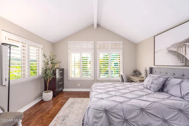 a spacious bedroom with a bed a couch and large window