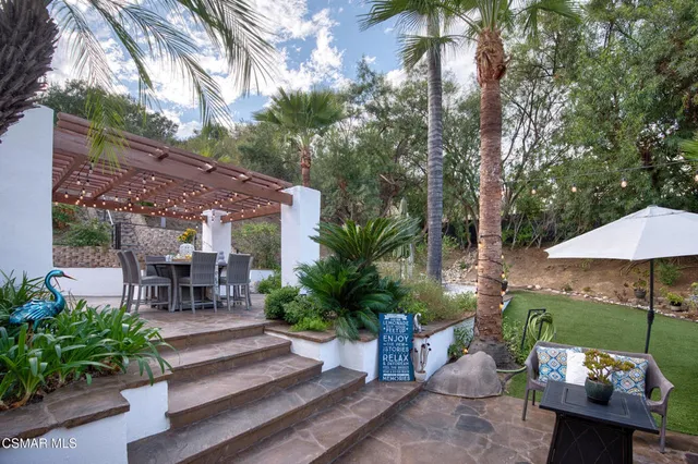 a view of a house with a big yard and large trees