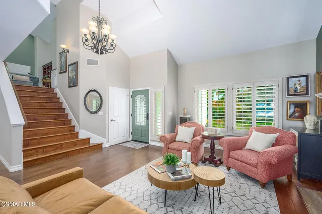 a living room with furniture chandelier and a large window