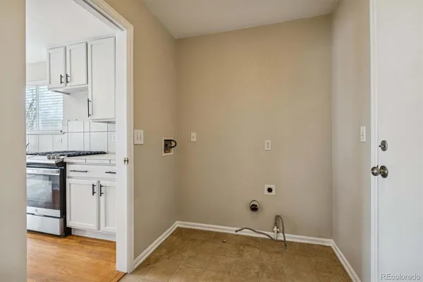 a view of a kitchen with white cabinets and wooden floor