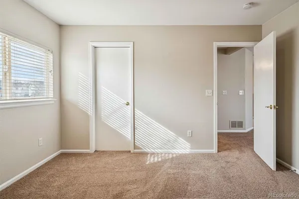 an empty room with windows and closet