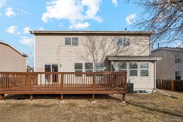 a view of a house with wooden deck and furniture