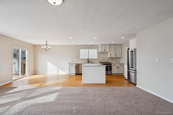 a view of kitchen with kitchen island refrigerator stove microwave and cabinets