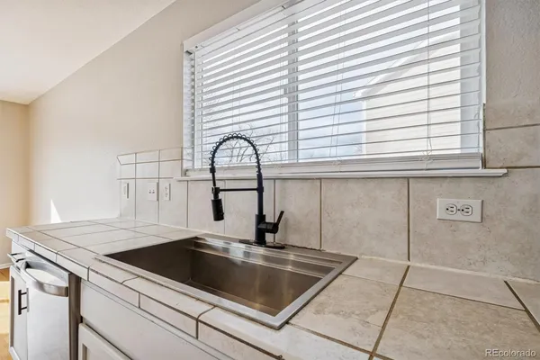a view of a kitchen counter top a sink and cabinets